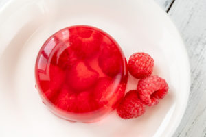 Portion of raspberry gelatin dessert on white plate