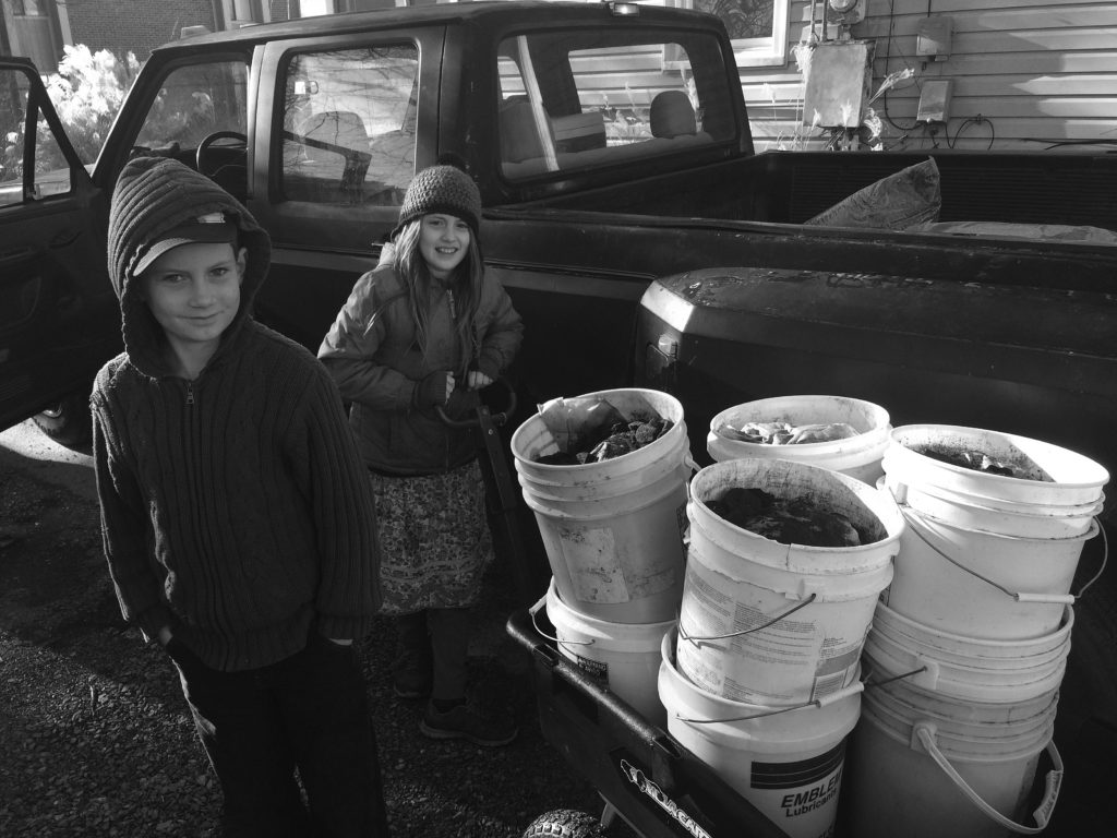 The Moody children move tons of earth and organic matter using a well-built garden cart.